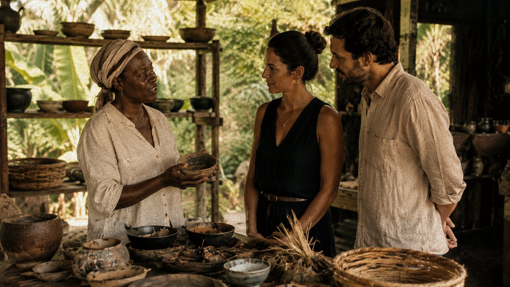 A local maker showing a finished bowl to two guests among her pottery workshop